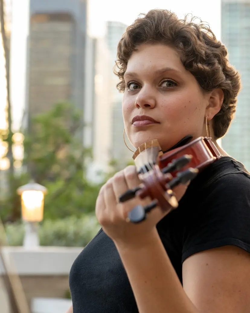 Olivia Eakes, founder and director of Triad Suzuki Academy, holding her violin
